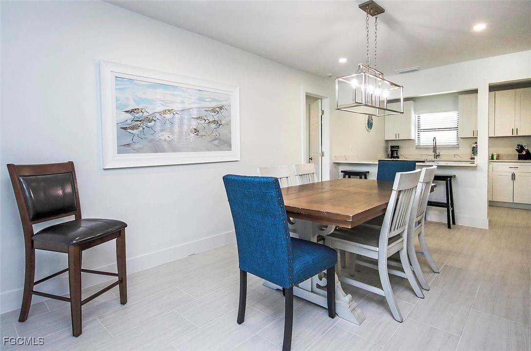 5117 Sea Bell Road, Unit E103 Sanibel, FL 33957 - Photo 6 of 24 a view of a dining room with furniture a chandelier and a window