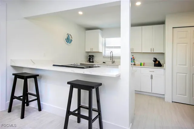 a kitchen with stainless steel appliances kitchen island a table chairs sink and cabinets