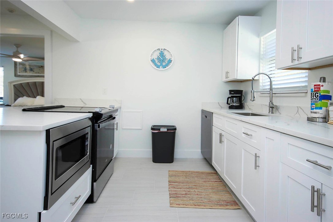 5117 Sea Bell Road, Unit E103 Sanibel, FL 33957 - Photo 8 of 24 a kitchen with granite countertop a sink stove and cabinets