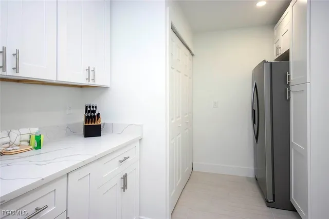 a kitchen with stainless steel appliances white cabinets and a refrigerator