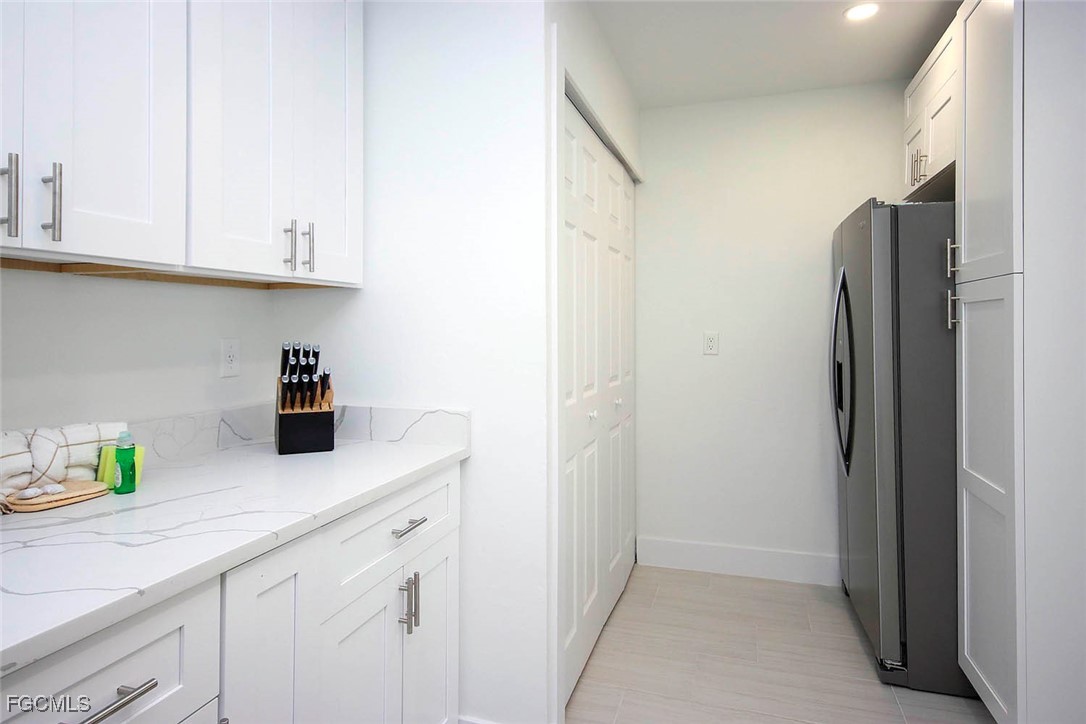 5117 Sea Bell Road, Unit E103 Sanibel, FL 33957 - Photo 10 of 24 a kitchen with stainless steel appliances white cabinets and a refrigerator