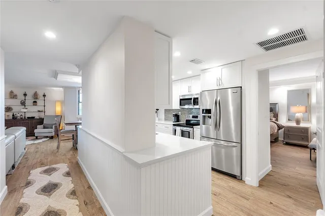 a kitchen with granite countertop a sink a stove a refrigerator and cabinets