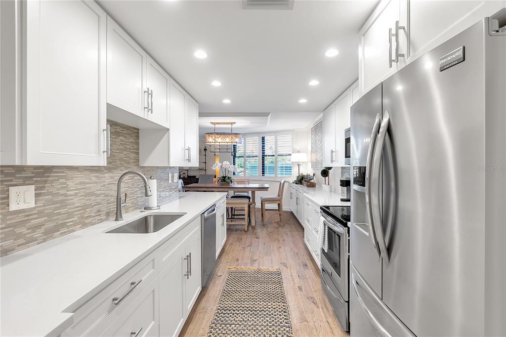 1000 Longboat Club Road, Unit 204 Longboat Key, FL 34228 - Photo 13 of 66 a kitchen with granite countertop a refrigerator and a sink