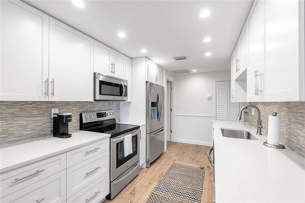 1000 Longboat Club Road, Unit 204 Longboat Key, FL 34228 - Photo 15 of 66 a kitchen with granite countertop a sink a stove a refrigerator and cabinets