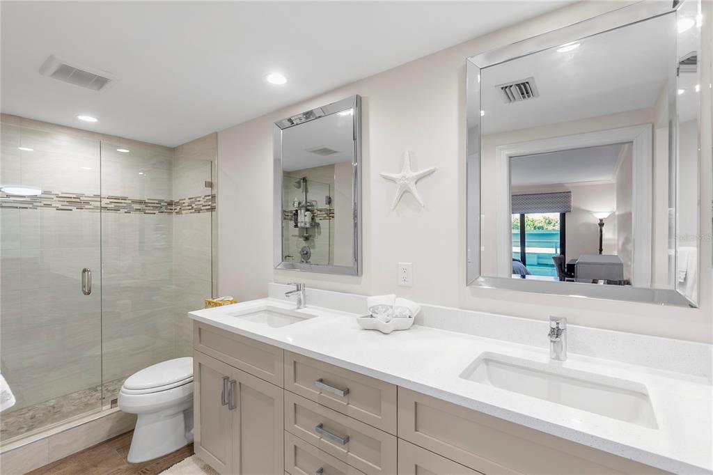 1000 Longboat Club Road, Unit 204 Longboat Key, FL 34228 - Photo 29 of 66 a bathroom with a granite countertop sink toilet a large mirror a shower and a mirror