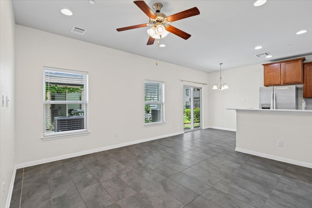 1502 Airedale Road, Unit 2502 Austin, TX 78748 - Photo 7 of 28 A combined living area and kitchen featuring ceramic tile flooring, a ceiling fan, and stainless steel appliances.