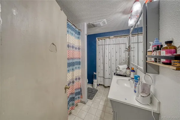 a bathroom with a sink a toilet and shower curtain