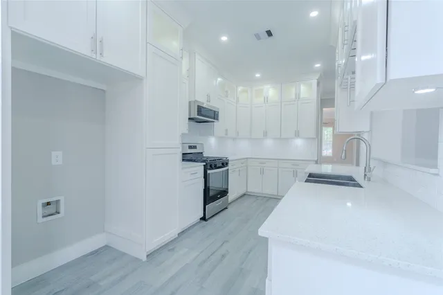 a kitchen with a sink stainless steel appliances and cabinets