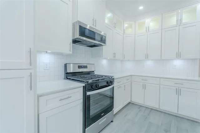 a kitchen with stainless steel appliances granite countertop white cabinets a sink and dishwasher