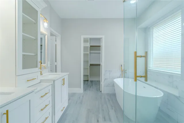 a spacious bathroom with a tub sink shower and mirror