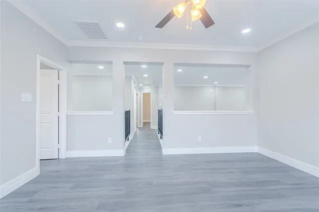 a view of a big room with wooden floor and windows