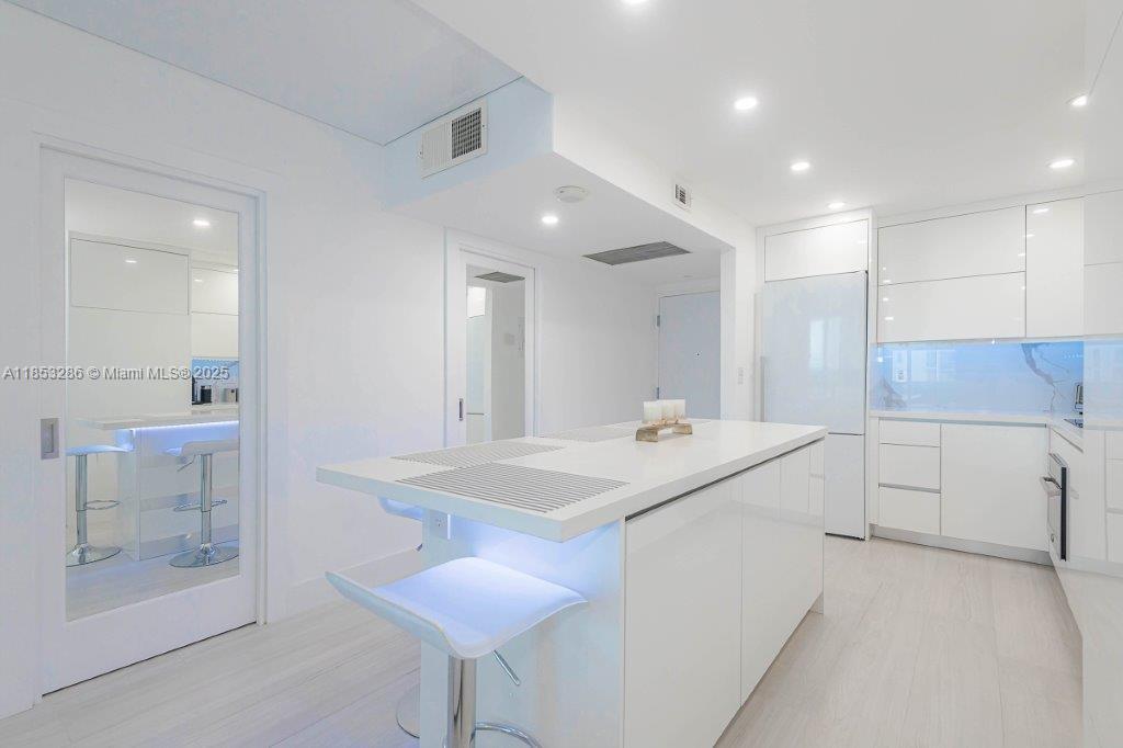 2301 Collins Avenue, Unit 811 Miami Beach, FL 33139 - Photo 19 of 42 a kitchen with a sink a stove cabinets and counter space