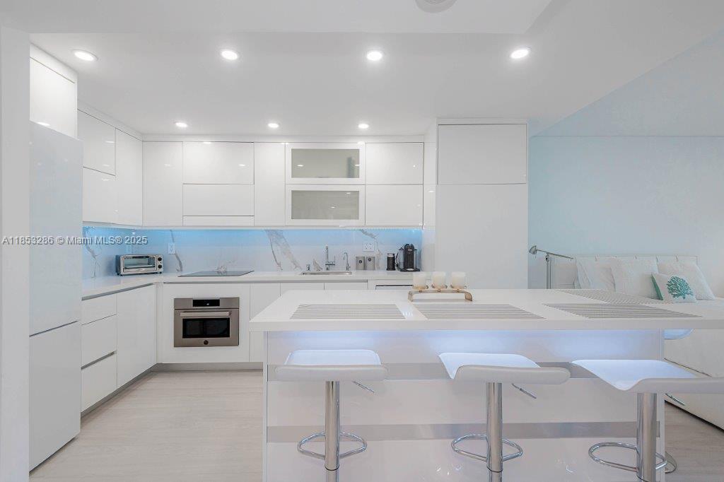 2301 Collins Avenue, Unit 811 Miami Beach, FL 33139 - Photo 21 of 42 a kitchen with a sink cabinets and wooden floor