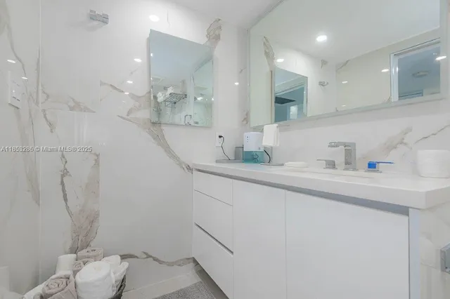 a bathroom with a granite countertop sink a toilet and a shower