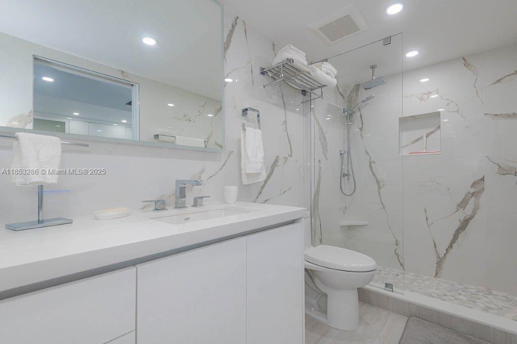2301 Collins Avenue, Unit 811 Miami Beach, FL 33139 - Photo 23 of 42 a bathroom with a granite countertop sink a toilet and a shower