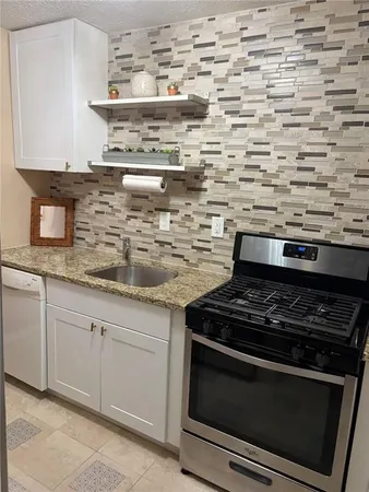 a stove top oven sitting inside of a kitchen