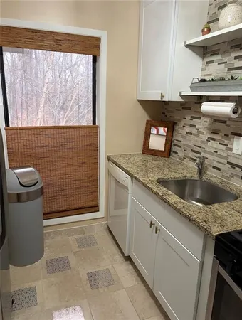 a kitchen with a sink a stove and cabinets