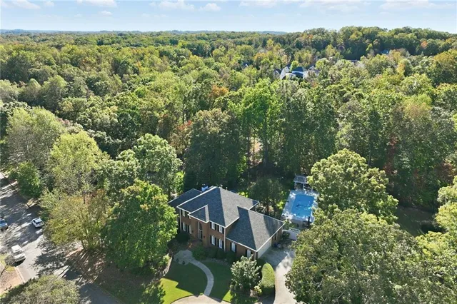 a kitchen with stainless steel appliances granite countertop a refrigerator a sink dishwasher a stove and white countertops with wooden floor