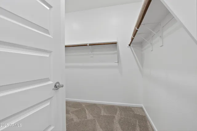 a view of walk in closet with empty racks