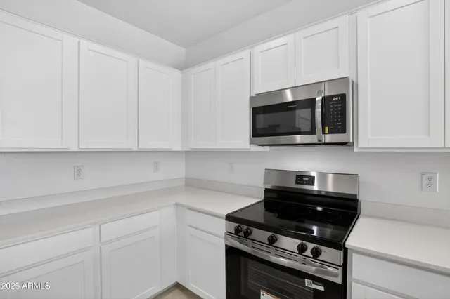 a kitchen with stainless steel appliances a stove a microwave and cabinets