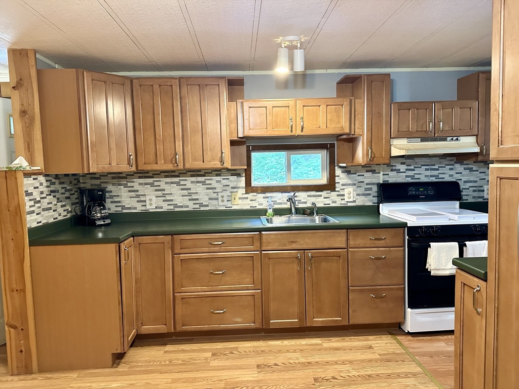 55 Heath Road Colrain, MA 01340 - Photo 15 of 32 a kitchen with granite countertop wooden cabinets a sink and a stove