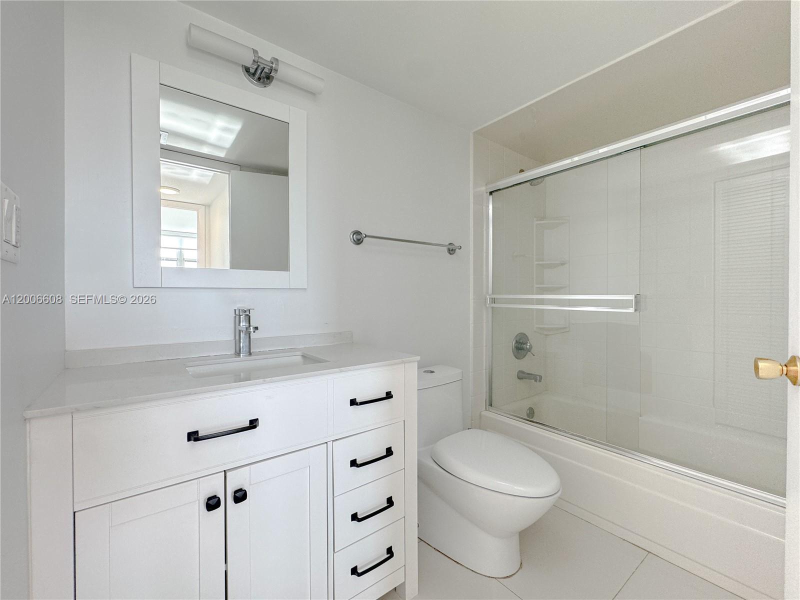 210 Seaview Drive, Unit 403 Key Biscayne, FL 33149 - Photo 12 of 31 a bathroom with a granite countertop toilet a sink and a mirror