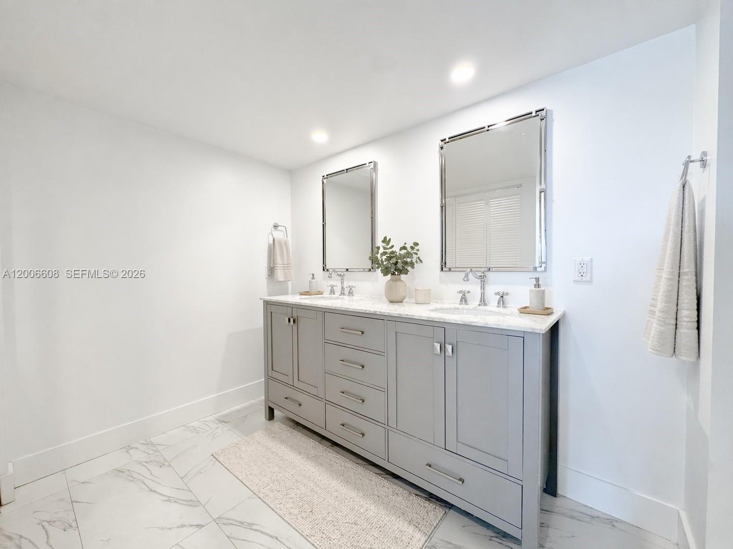 210 Seaview Drive, Unit 403 Key Biscayne, FL 33149 - Photo 19 of 31 a bathroom with a double vanity sink and a mirror