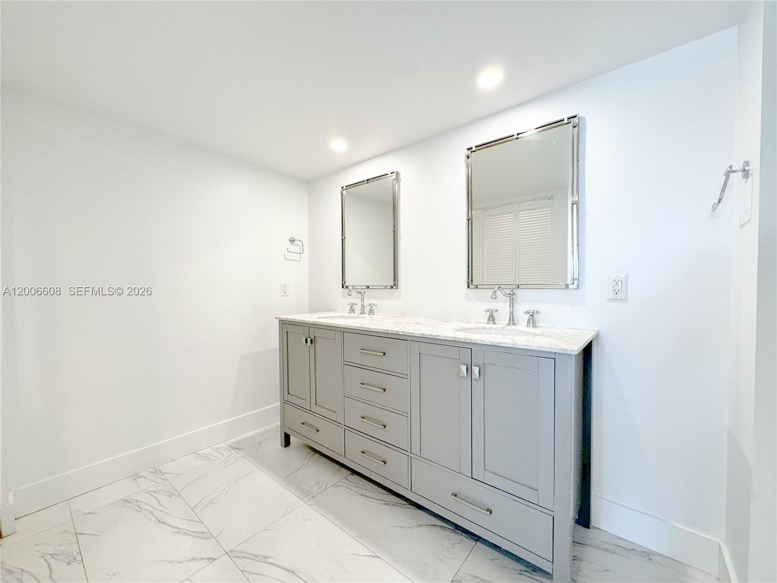 210 Seaview Drive, Unit 403 Key Biscayne, FL 33149 - Photo 20 of 31 a bathroom with a double vanity sink and mirror