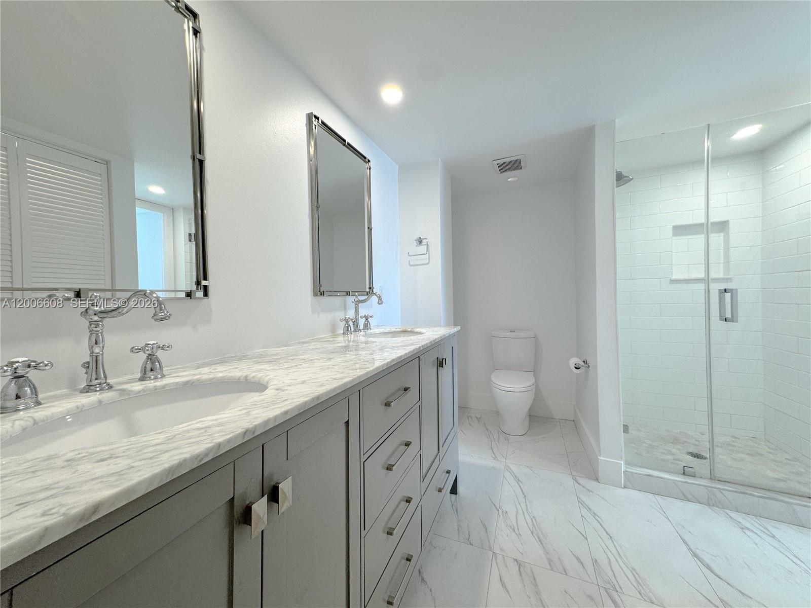 210 Seaview Drive, Unit 403 Key Biscayne, FL 33149 - Photo 21 of 31 a spacious bathroom with a granite countertop sink a toilet a shower and a mirror
