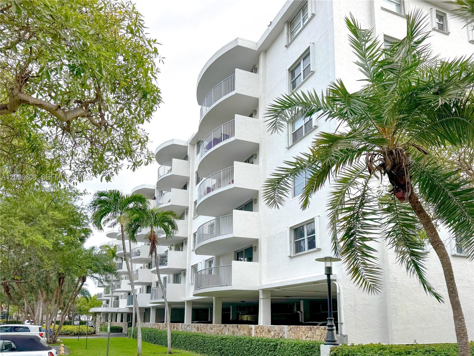210 Seaview Drive, Unit 403 Key Biscayne, FL 33149 - Photo 30 of 31 a front view of multi story residential apartment building with yard and parking space