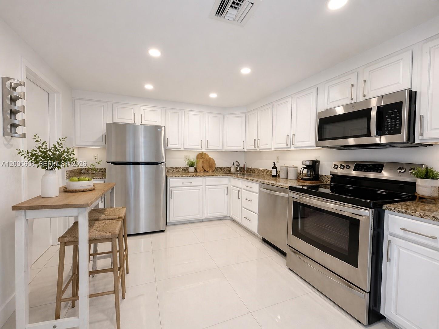 210 Seaview Drive, Unit 403 Key Biscayne, FL 33149 - Photo 5 of 31 a kitchen with a refrigerator a stove top oven a sink and cabinets
