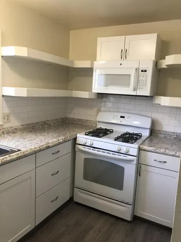 a white stove top oven sitting inside of a kitchen