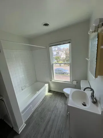 a bathroom with a sink a bathtub and a window
