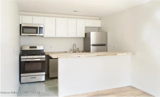 a kitchen with stainless steel appliances granite countertop a stove a sink and a microwave