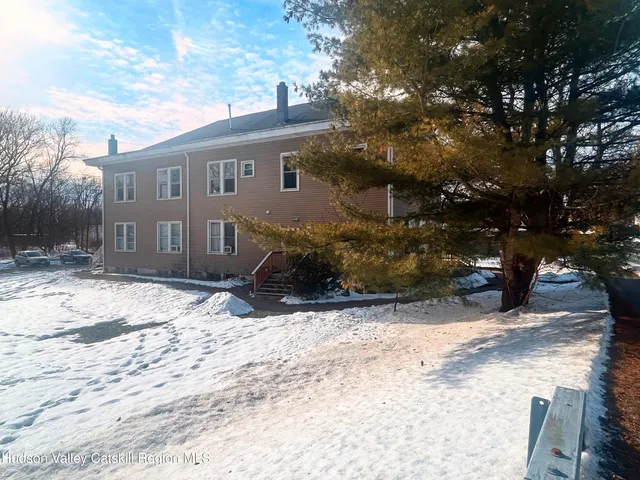 a view of a house with a yard covered in snow