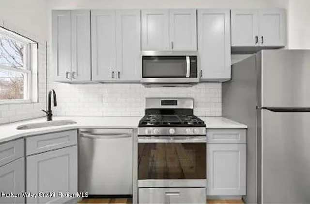 a kitchen with white cabinets and stainless steel appliances