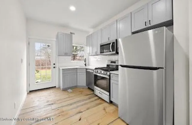 a kitchen with stainless steel appliances a refrigerator sink and cabinets