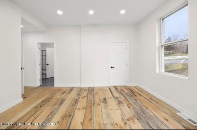 a view of a room with wooden floor and a window