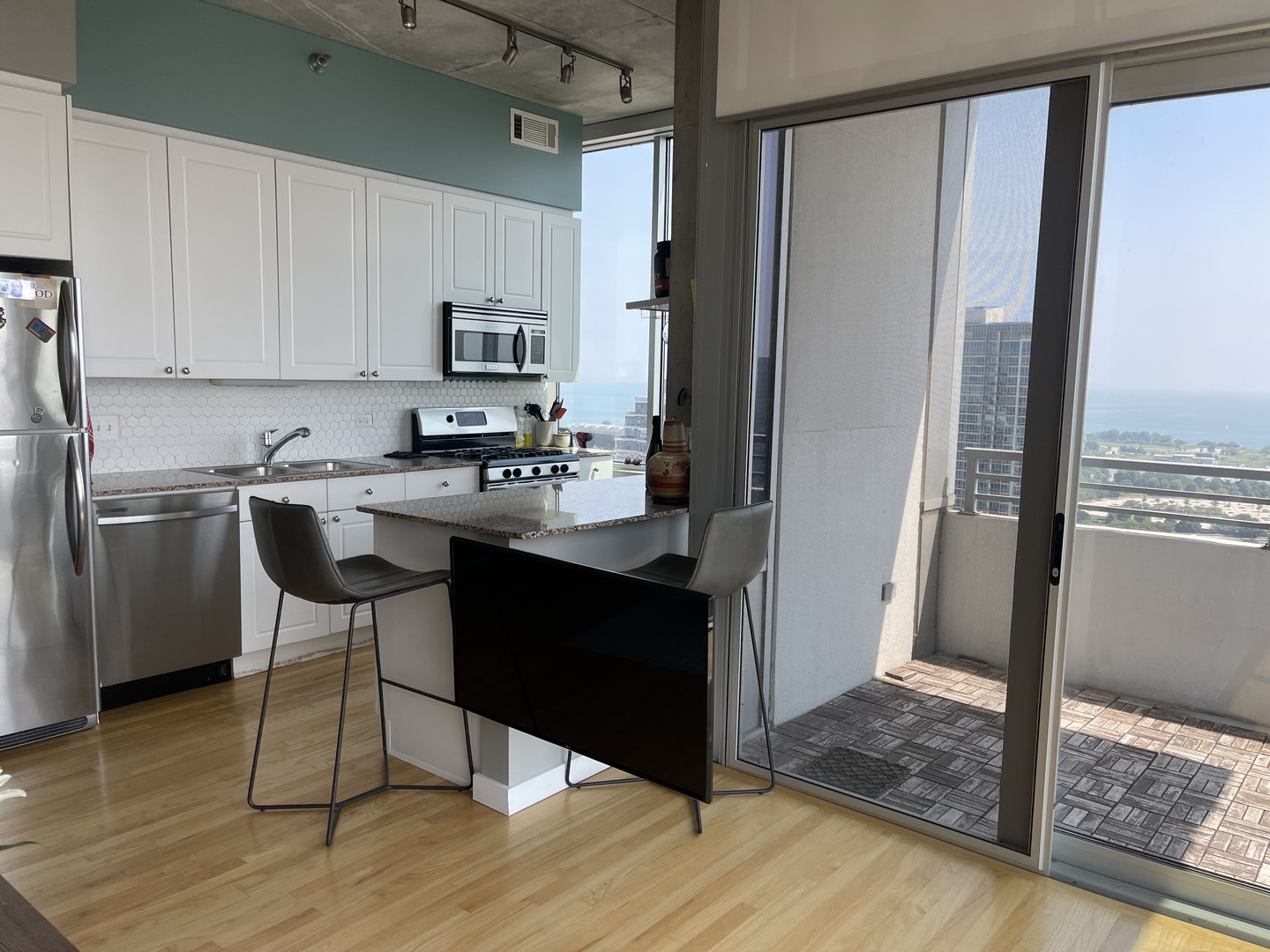1720 South Michigan Avenue, Unit 2708 Chicago, IL 60616 - Photo 8 of 18 a kitchen with stainless steel appliances granite countertop a refrigerator and a stove top oven