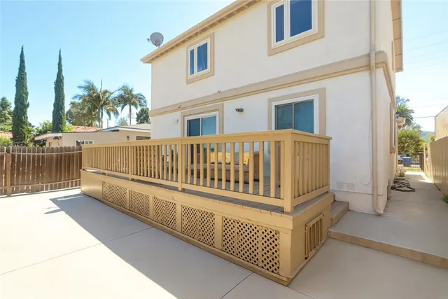 a view of a white house with wooden fence