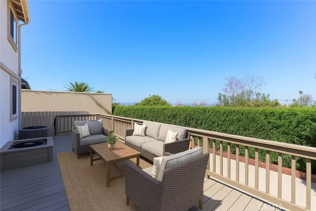 a view of roof deck with couches and sky view