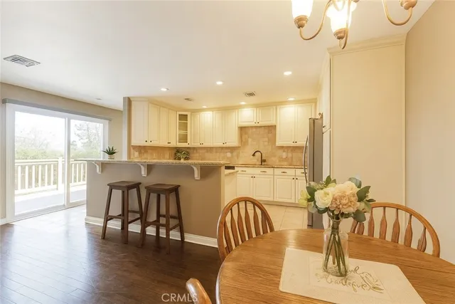 a dining room with furniture a chandelier and wooden floor
