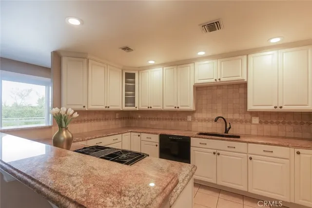 a kitchen with stainless steel appliances granite countertop a sink and a white cabinets