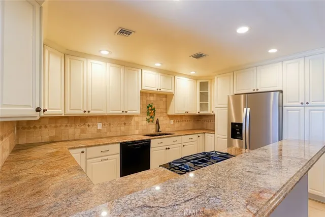 a kitchen with stainless steel appliances granite countertop a sink stove and refrigerator