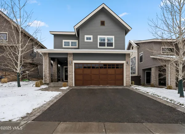 a front view of a house with yard and parking
