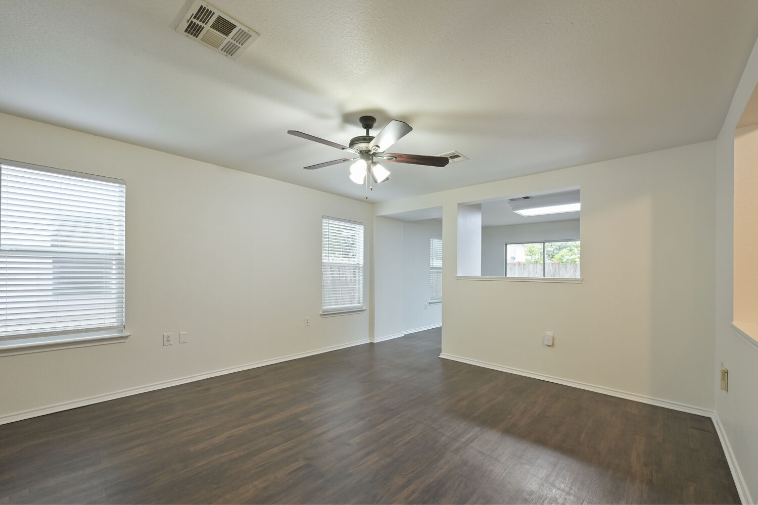 6733 Doyal Drive Austin, TX 78747 - Photo 6 of 28 An inviting room features rich wood flooring and abundant natural light from multiple windows.