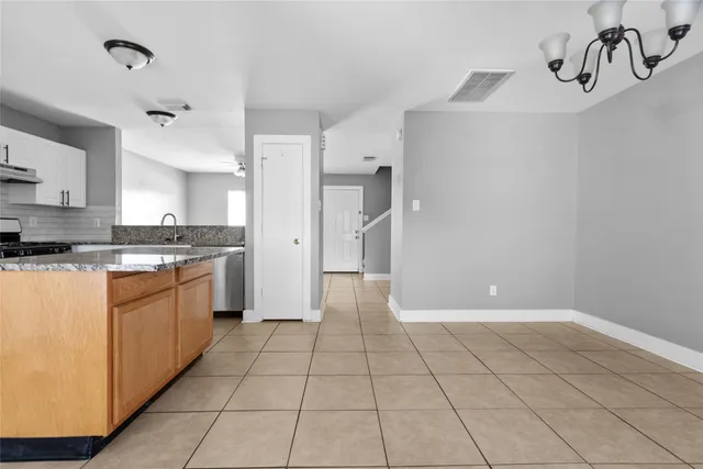 a large white kitchen with a stove a refrigerator and a sink