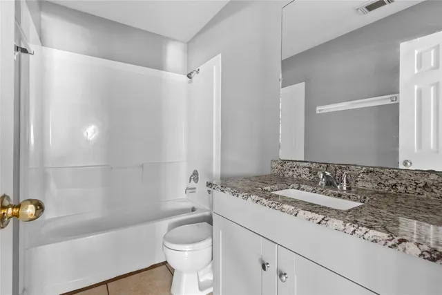 a bathroom with a sink a toilet a mirror and bathtub