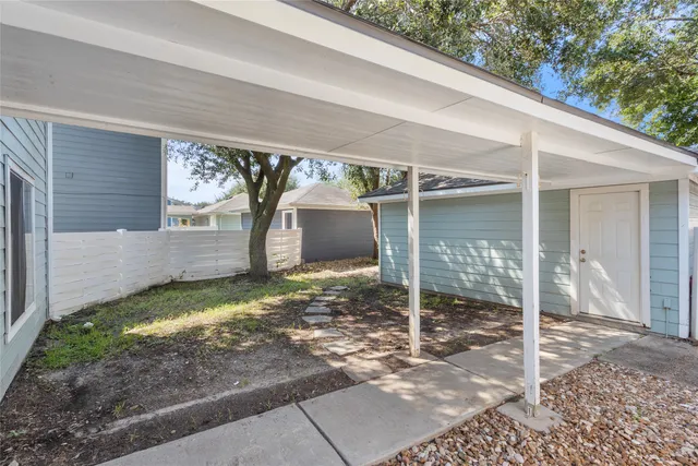 a view of a barn house next to a yard with wooden fence