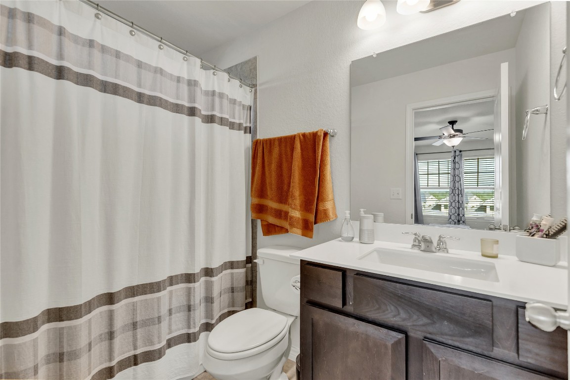 380 Witchhazel Way San Marcos, TX 78666 - Photo 17 of 22 a bathroom with a sink a toilet and shower curtain